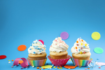Tasty cupcakes on color background