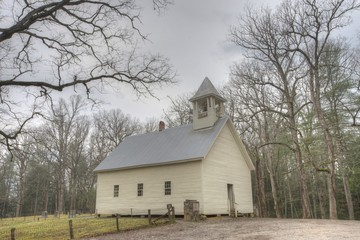 Little white church in Cades Cove framed by bare winter trees.