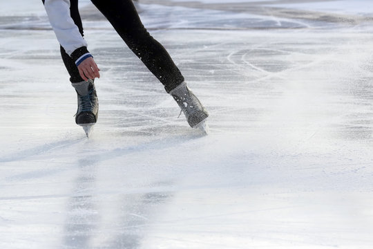 feet on the skates of a person rolling on the ice rink.
