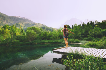 Young woman with raised arms up on the nature background.