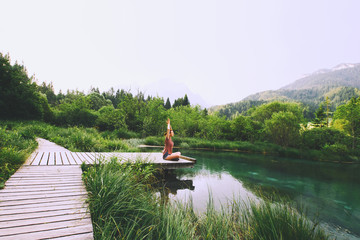 Woman doing yoga and meditating in lotus position on the nature.