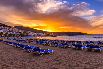 Beach Playa de Las Vistas with sun loungers at sunrise on Tenerife, Canary Islands, Spain
