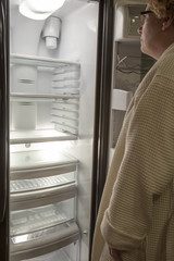 Woman looking at empty refrigerator