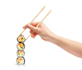 Stack of sushi rolls with wooden chopsticks in female hand, isolated on white background