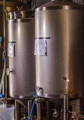 Indoor view of a modern beer plant brewery with vessels, tubs and pipes made of stainless steel, in a beer plant in Quito