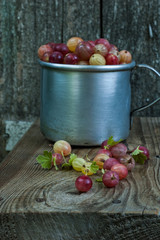 Many ripe berries of gooseberry on a wooden background.