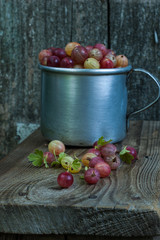 Many ripe berries of gooseberry on a wooden background.