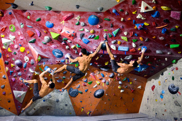Athletic man training in a climbing gym, bouldering. Indoor workout.