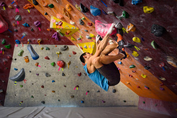Workout exercise. Athletic male on a climbing wall, indoor sports.