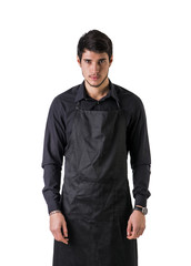 Young chef or waiter posing, wearing black apron and shirt isolated on white background