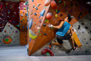 Man climber in bouldering gym.Indoor workout exercise. © juliet_boo