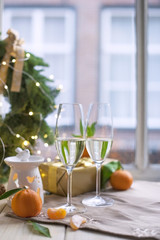 two glasses of champagne, fruit on the table by the window