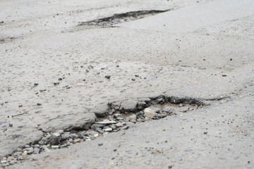 Fototapeta na wymiar Potholes. Potholes dangerous to motorists and pedestrians.