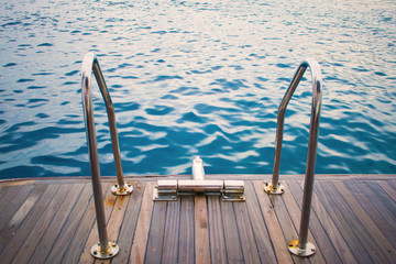 view of the yacht's gangway against the azure sea. relax. swimming. wooden deck and gangway