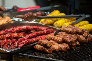 Traditional romanian food meat balls - mici, spare ribs and corn baked on grill