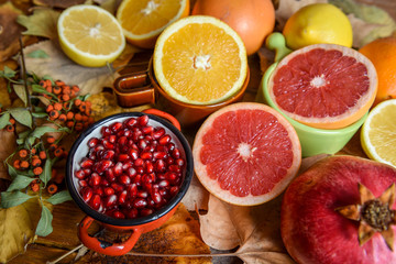 Tropical fruits with mix of lemons, oranges, grapefruit, pomegranate on a vintage wooden board
