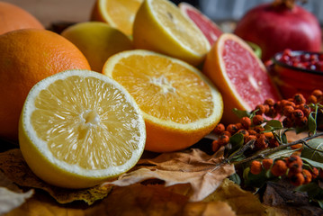 Tropical fruits with mix of lemons, oranges, grapefruit, pomegranate on a vintage wooden board