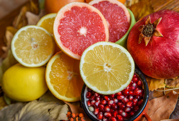 Mix of tropical fruits with lemon, orange, grapefruit, pomegranate on a vintage wooden board