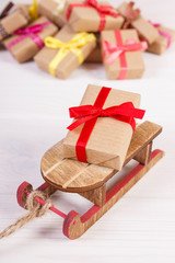 Wooden sled and wrapped gifts with ribbons for Christmas or other celebration