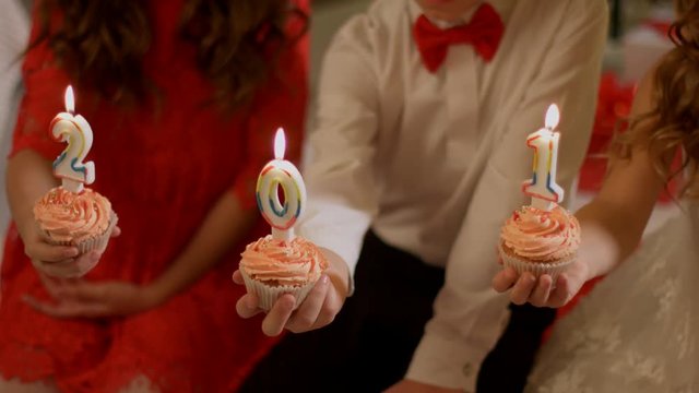 Children blowing out the candles 2018 on cakes