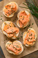 Smoked salmon sandwiches with chives, photographed overhead with natural light (Selective Focus, Focus on the top of the sandwiches)
