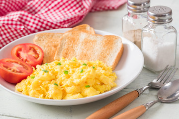 Scrambled egg served with toast and tomato