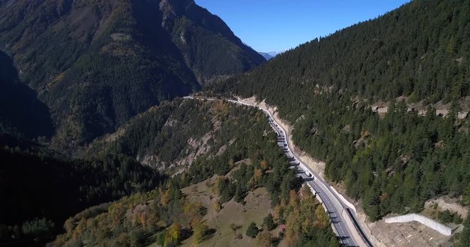 Cars on a alpine road, Cinema 4k aerial view following cars and trucks driving on a mountain road, on a sunny fall day, on simplon pass, in wallis, of the alps in Switzerland