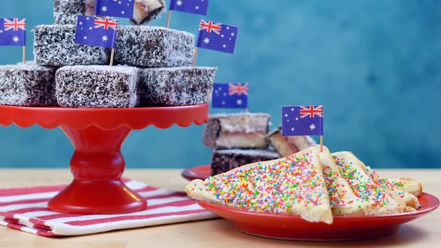 Iconic traditional Australian party food, Lamington cakes and Fairy Bread, on a red, white and blue background.