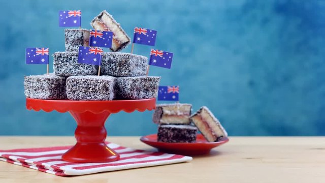 Iconic traditional Australian party food, Lamington cakes and Fairy Bread, on a red, white and blue background.