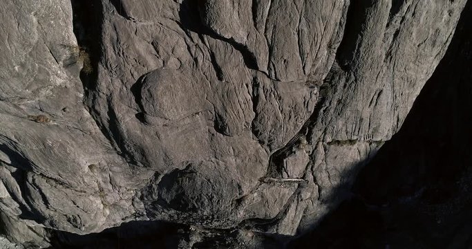 Cabin on a mountain, aerial backward tilt view revealing a hut cottage on a bare, grey cliff, near Grindelwald, on a sunny fall evening dusk, in the berner oberland, in the alps of Switzerland