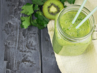Freshly made smoothies of avocado with herbs and two cocktail straws on a dark rustic table. Diet vegetarian food.