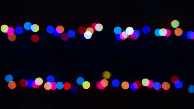 Two rows of colorful blinking twinkling out of focus festive holiday lights isolated on black with copy space
