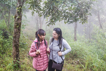 Asia girl Mother and daughter backpack behind go hiking or climbing in Nature Mountain.