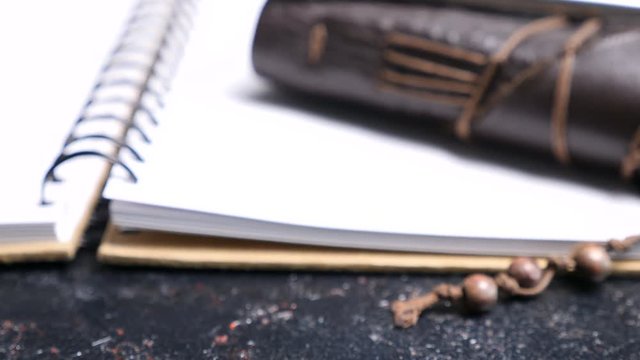Close up zoom in dolly footage on leather vintage retro notebook on a dark table. Old type diary
