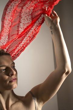 Young Woman Head And Shoulders With Red Scarf Floating Above.