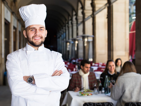 Portrait of happy male chef standing in restaurant