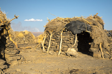 Rock, wood and grass huts erected by the Afar people at the foot of Erta Ale volcano.