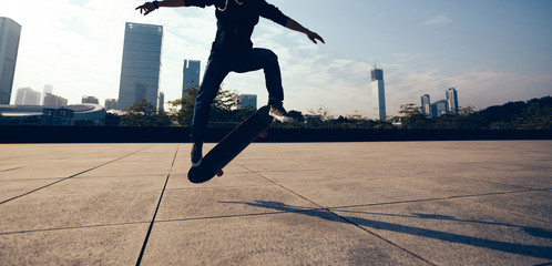female skateboarder doing a hand on skateboard in city