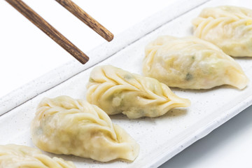 Fresh boiled dumpling on plate. Chinese food with hot steams on background.