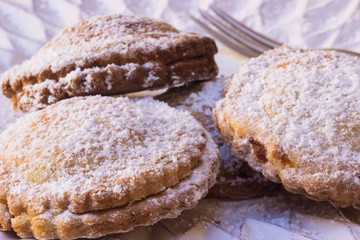 Traditionnelle Englische Mince-Pies zum Jahreswechsel mit Puderzucker auf einem weißen Teller