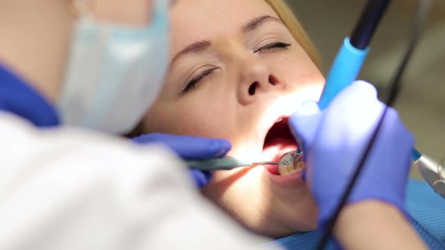 Dental treatment of young woman at the dentist office. Dentistry.