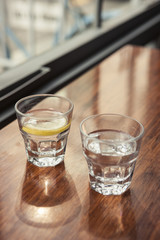 water and lemon with cup(glass) on the wood table.