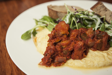 omelet with spicy chicken with bread on the white dish.