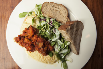 omelet with spicy chicken with bread on the white dish.