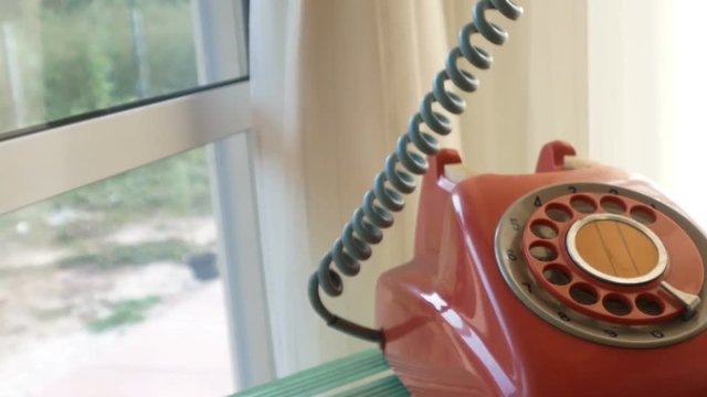 Dialing on a red vintage telephone