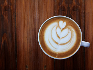 up of love , heart latte art coffee in white cup on the vintage wooden table. Love coffee love in your cup. Wake up and full fill energy, top view. Clipping path