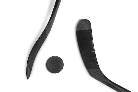 Two black sticks and a hockey puck