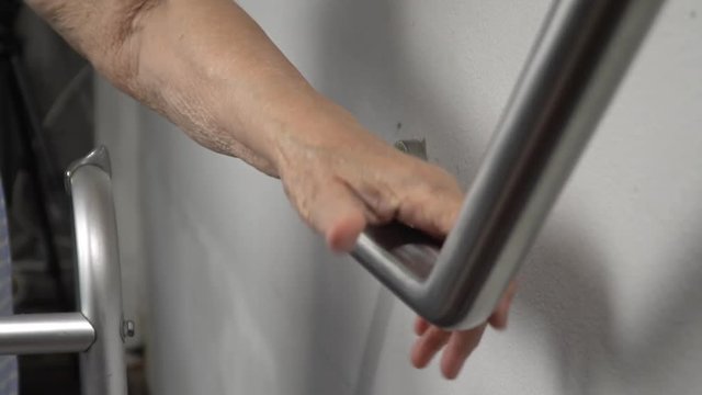Elderly woman holding on handrail for safety walk steps