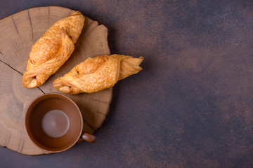 Two fresh croissants and empty cup