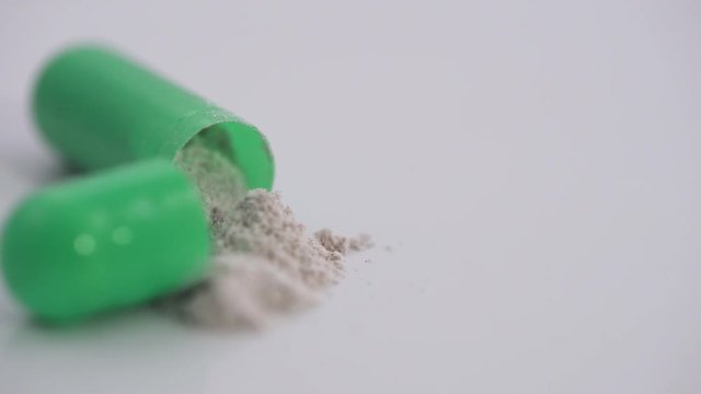 Pharmaceuticals and drugs, view of the opened capsule with medicine, isolated.

